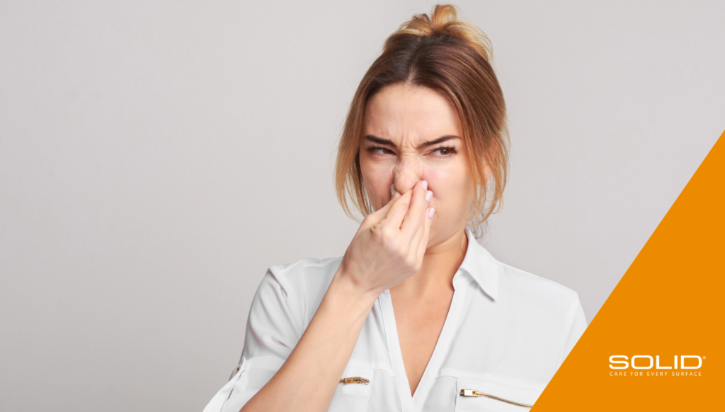 Woman holding her nose reacting to a bad odor